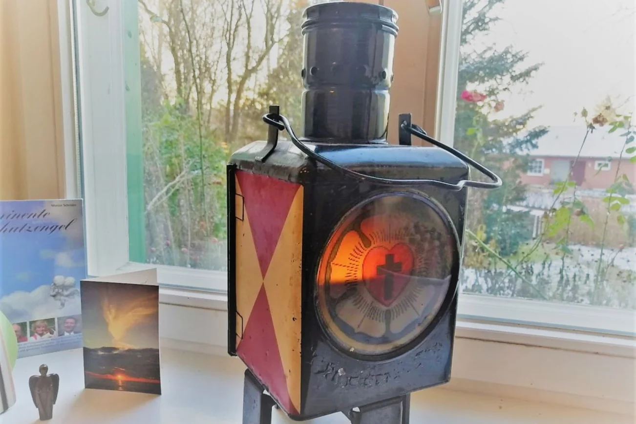 Schwarze Sturmlaterne mit dem Friedenslicht auf der Fensterbank