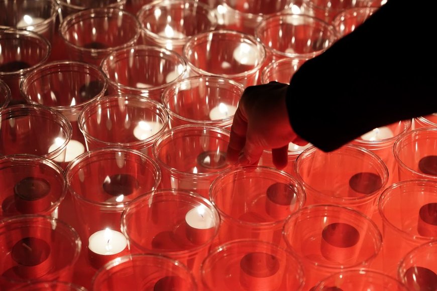 Angezündete Teelichter in Gläsern auf roten Untergrund - Copyright:  Foto: epd bild/Peter Endig