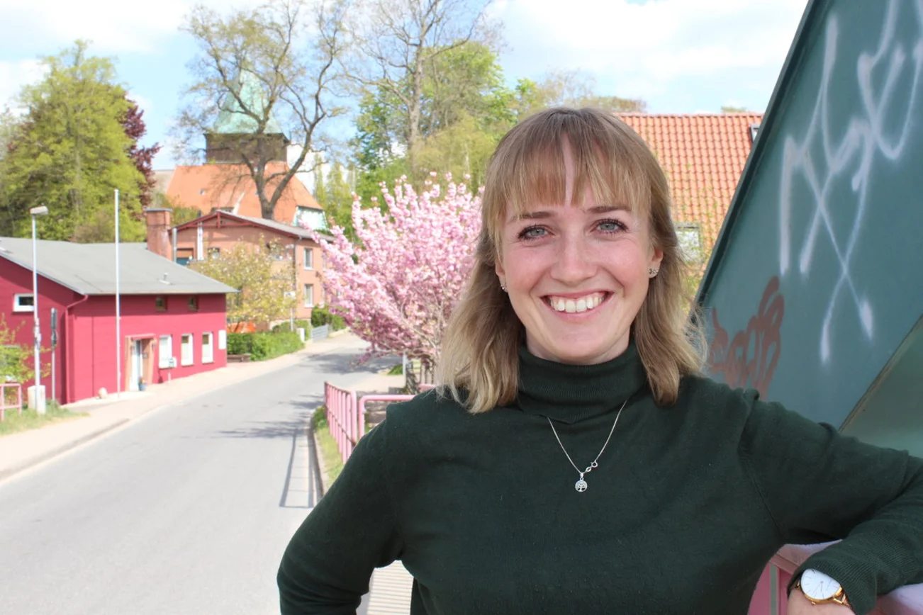 Eine Frau blickt lächelnd in die Kamera.