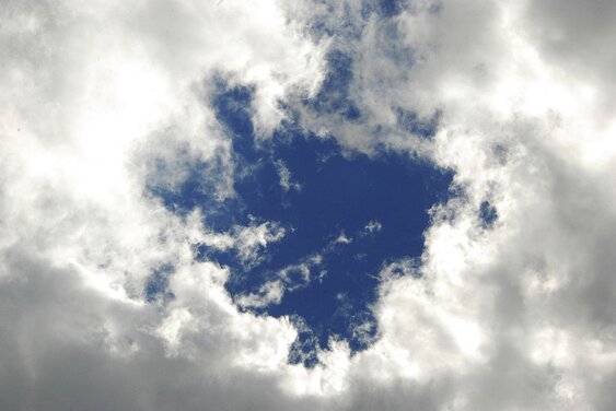 Ein Kreis blauer Himmel leuchtet durch eine Wolkendecke - Copyright:  Foto: Lotz
