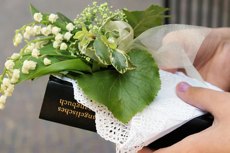 Gesangbuch, Maiglöckchen und Taschentuch