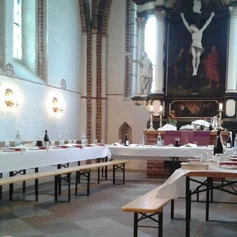 Gedeckte Tische und Bänke im Altarraum der St. Johanniskirche zu Krummesse
